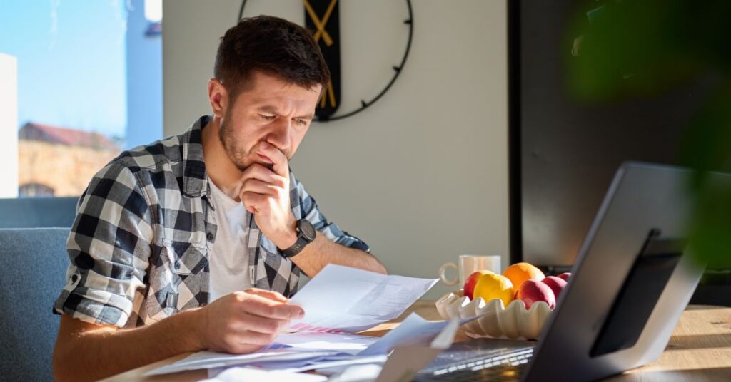 man comparing health insurance plans laptop